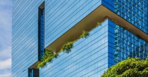 A tall green office building overflowing with plants.