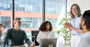 Group of office workers in a meeting, smiling.